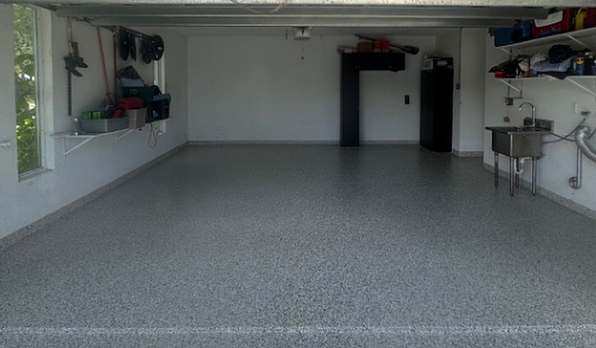 Garage floor after epoxy flake coating: clean, seamless gray and black flake floor